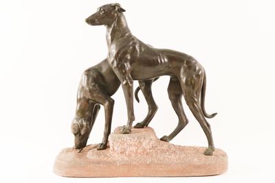 statue of two greyhounds standing on a rock on a white background
