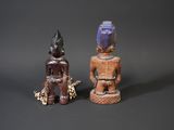 two wooden figurines of a man and a woman on a black background
