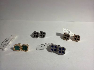 three pairs of earrings and a pair of earrings are on a table