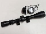 a close up of a rifle scope and a compass on a table