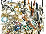 une pile de bijoux assortis sur une surface blanche
