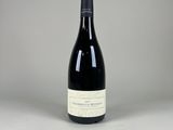 une bouteille de vin posée sur une table blanche
