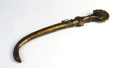 un vieux tuyau en laiton muni d'une poignée, posé sur une surface blanche