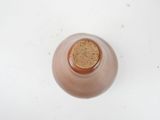 a brown bottle with a cork on it on a white surface