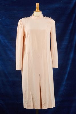une robe posée sur un mannequin, devant un fond bleu