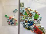 un réfrigérateur recouvert de timbres et d'aimants, accroché au mur