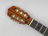 a close up of a guitar with a wooden neck and strings