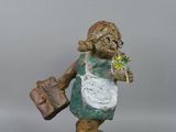 figurine of a woman with a bag and a flower in her hand