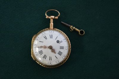une montre à gousset en or à laquelle est attachée une clé