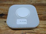 a close up of a white smoke detector on a wooden table