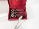 silverware in a red case on a white surface with a spoon and fork in it