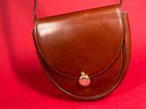 brown leather handbag on a red background with a red background