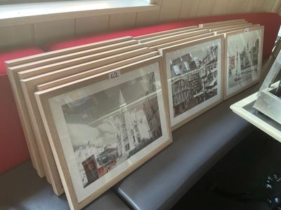 quatre photos accrochées au mur à côté d'un ordinateur portable