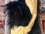 a mannequin wearing a yellow dress with black feathers on it