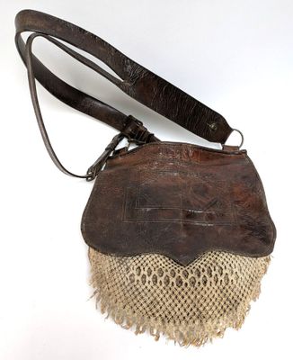 an old purse with a lace and leather handle on a white background