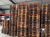 many pallets stacked up in a warehouse with a fork