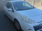la petite voiture blanche est garée sur le bord de la route