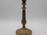 an antique brass candle holder on a white background
