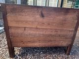 a wooden bed with a wooden head board on top of it