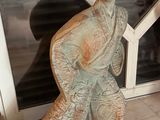 une statue représentant un homme debout devant une fenêtre