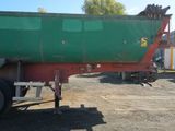 a green and red dump truck parked in a parking lot