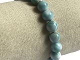 bracelet avec des perles bleues posé sur une serviette, sur fond blanc