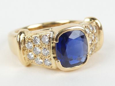 a close up of a gold ring with a blue sapphire and white diamonds
