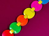 brightly colored wooden beads on a purple background