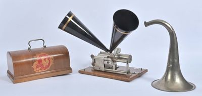 un téléphone à cornet argenté et noir posé à côté d'un coffret en bois