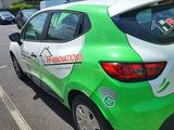 a green and white car parked in front of a building