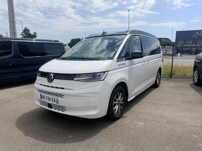 la camionnette blanche est garée dans le parking à côté d'autres voitures