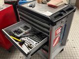 un chariot à outils contenant des outils, dans un garage