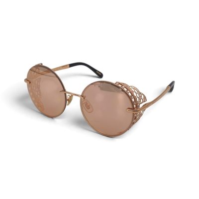 Ces lunettes de soleil sont en métal et ont des verres teintés en rose.