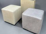three different colored stools sitting next to each other on a gray surface