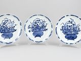 trois assiettes bleues et blanches ornées de fleurs dans des vases