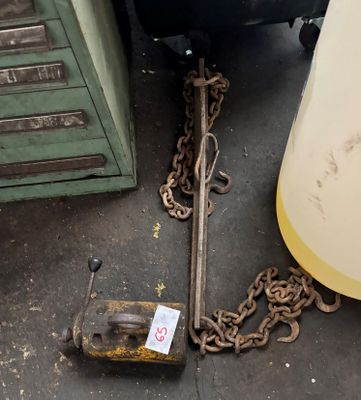 une chaîne et un marteau posés par terre à côté d'une poubelle