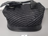 a close up of a black purse on a table with a price tag