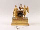 a gold clock with angels and a bird on top of it