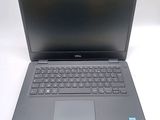 dell laptop computer on a white surface with a black keyboard