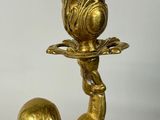 a gold statue of a person holding a candle