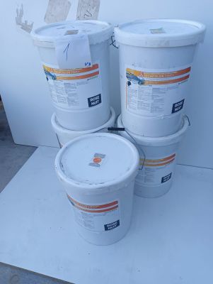 several buckets of paint sitting on top of a white table