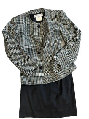 La veste est noire et blanche, avec un motif à carreaux.