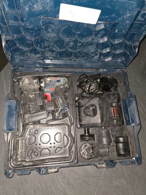une boîte à outils ouverte, contenant des outils, posée par terre