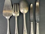 four forks and a knife on a table with a spoon and a knife