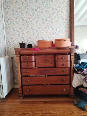 a dresser and a mirror in a room with a floral wallpaper