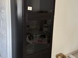 une armoire noire avec une porte vitrée dans une pièce