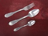three spoons and a fork sitting on a table