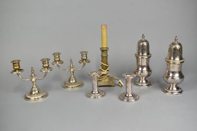 a lot of silver candles that are sitting on a table