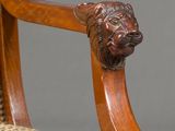 an image of a wooden chair with a lion head on the back