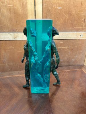 un vase en verre contenant une statuette représentant deux personnes
